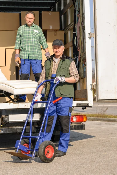 Два человека грузят мебель на грузовик — стоковое фото