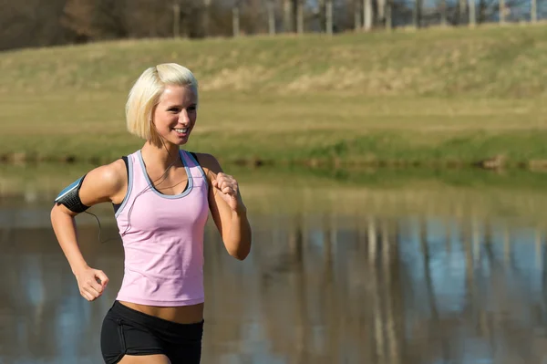 Young woman jogging lake park sunny day — Stock Photo, Image