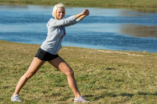 Młoda kobieta, rozciągający się na zewnątrz przed joggingu — Zdjęcie stockowe