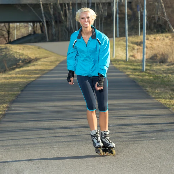 Mujer patinaje sobre ruedas en el parque sonriente verano — Foto de Stock