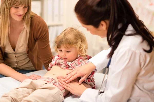 Pediatra examinar la panza del niño en el consultorio —  Fotos de Stock