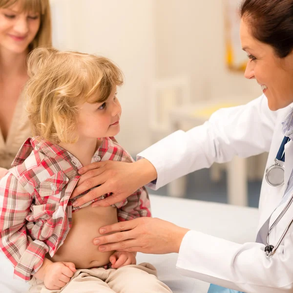 Pediatra examinar la panza del niño en el consultorio —  Fotos de Stock