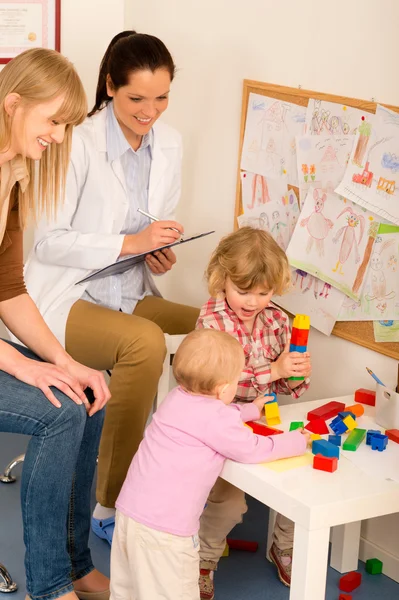 Pediatra revisão do sexo feminino crianças jogar atividade — Fotografia de Stock