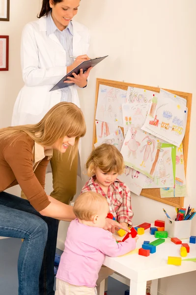 Pediatra revisão do sexo feminino crianças jogar atividade — Fotografia de Stock