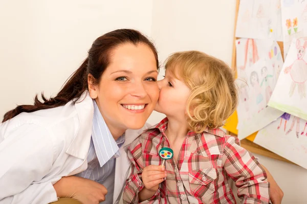 Pediatra kobiety dostać pocałunek od dziecko dziewczynka — Zdjęcie stockowe