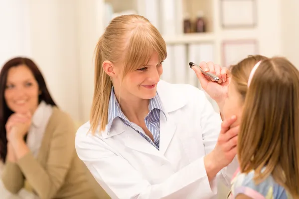Pediatra revisando a la chica de los ojos en el consultorio médico —  Fotos de Stock