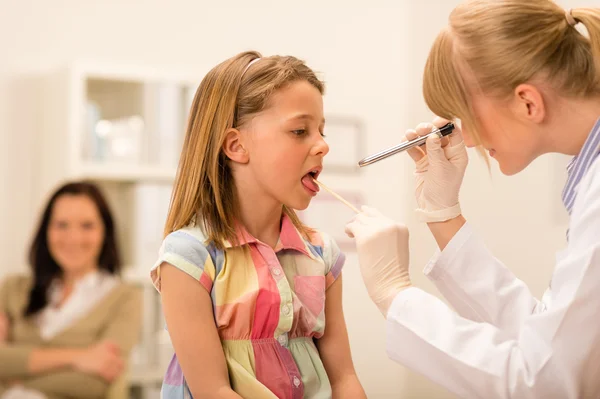 Pediatra bada dziewczyna gardła język — Zdjęcie stockowe