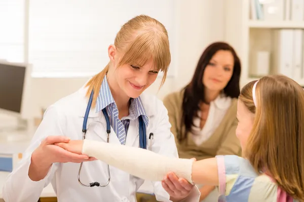 Pediatra verificando bandagem braço menina — Fotografia de Stock