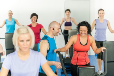 Fitness instructor leading class of alpinning clipart