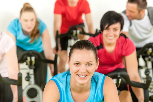 Mujer sonriente en la clase de spinning entrenamiento de fitness —  Fotos de Stock