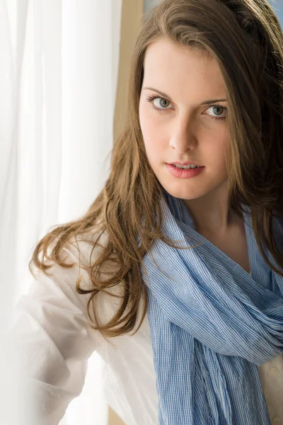 Jeune femme brunette regarder caméra derrière le rideau — Photo