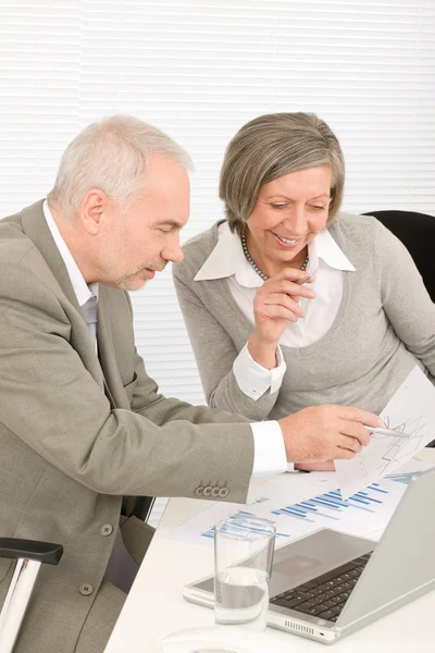 Happy senior businesspeople looking at graphs — Stock Photo, Image