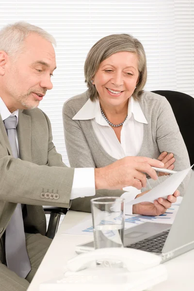 Happy senior businesspeople looking at graphs — Stock Photo, Image