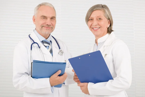 Ärzteteam Senioren halten lächelnd Ordner in der Hand — Stockfoto