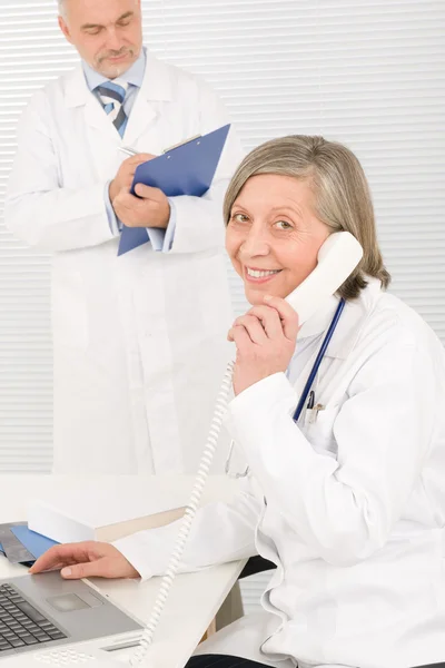 Lékařský tým starší ženské telefon mužský kolega — Stock fotografie