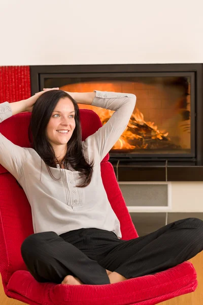 冬の家の暖炉女性リラックス赤い肘掛け椅子 — ストック写真
