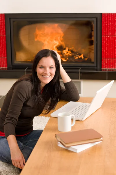 首页生活女人带壁炉的便携式计算机 — 图库照片