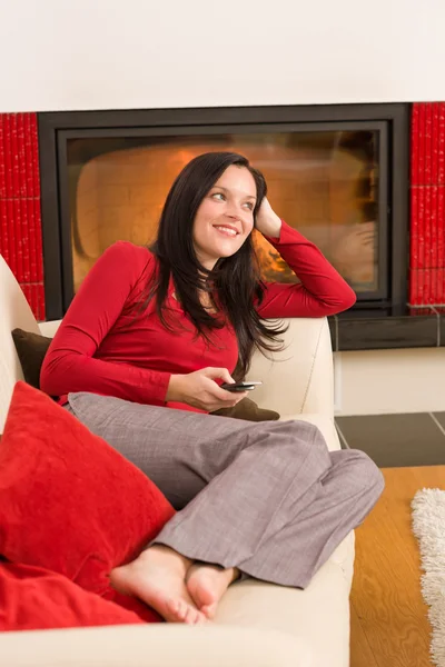 Fireplace woman with phone lying home sofa — Stock Photo, Image