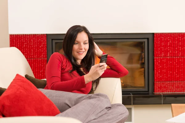 Spisen kvinna med telefonen liggande hem soffa — Stockfoto