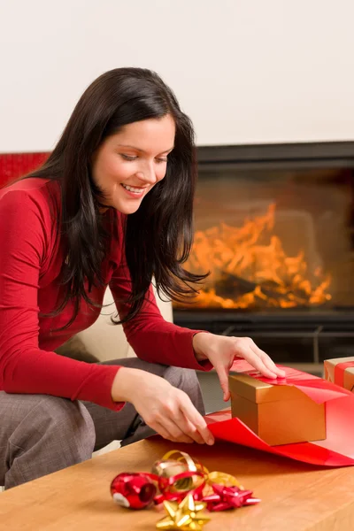 Karácsonyi wrap jelen boldog asszony otthon kandalló — Stock Fotó