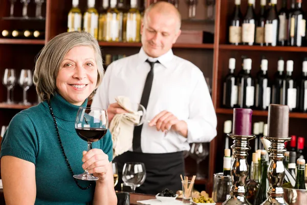 年配の女性ワインバー ワイン グラスをお楽しみください。 ストック画像