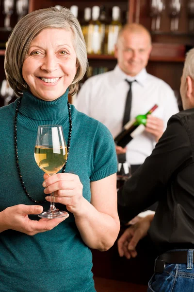 Wine bar senior woman barman discussing Stock Photo