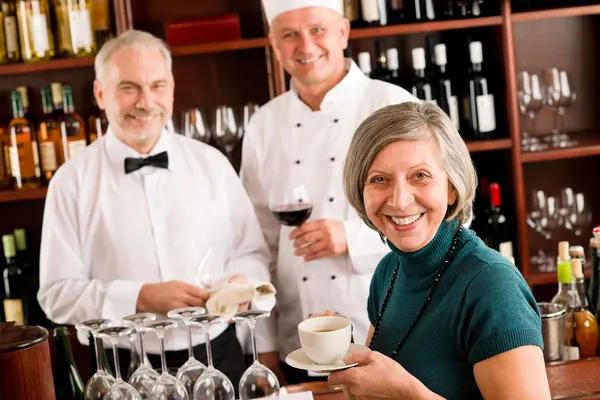 Χαμογελώντας διευθυντής εστιατορίου με προσωπικό μπαρ κρασιού Φωτογραφία Αρχείου
