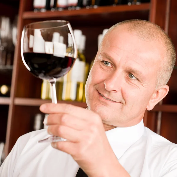 Официант винного бара смотрит на стеклянный ресторан — стоковое фото