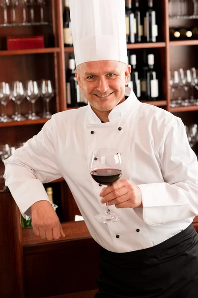 Шеф-повар держит бокал вина в ресторане — стоковое фото