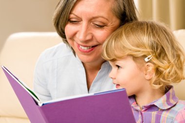 Grandmother and granddaughter read book together