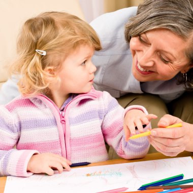 Little girl with grandmother drawing together clipart