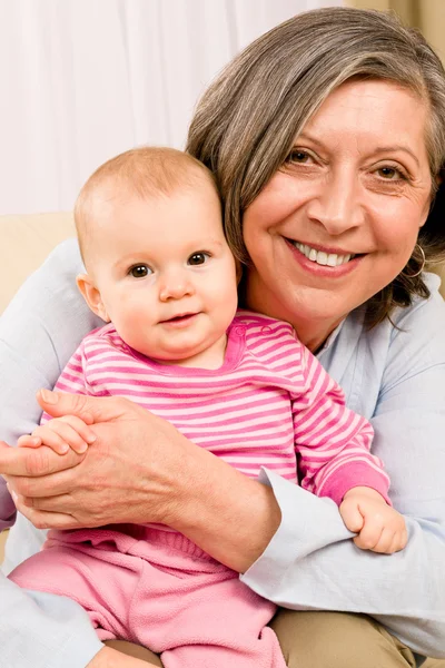 Großmutter hält kleines Mädchen lächelnd in der Hand — Stockfoto