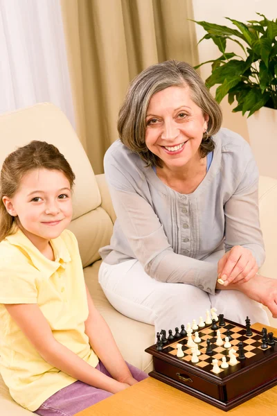 Бабушка и внучка вместе играют в шахматы. — стоковое фото