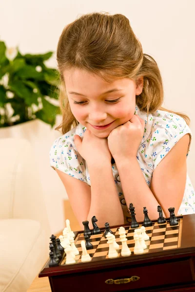 年轻的女孩玩棋可爱的笑容 — 图库照片