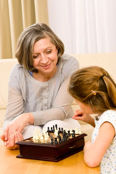 Бабушка и внучка вместе играют в шахматы. — стоковое фото