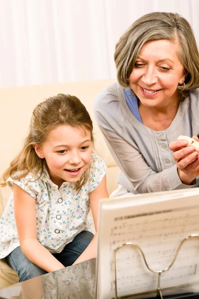 Nonna insegnare giovane ragazza imparare note musicali — Foto Stock