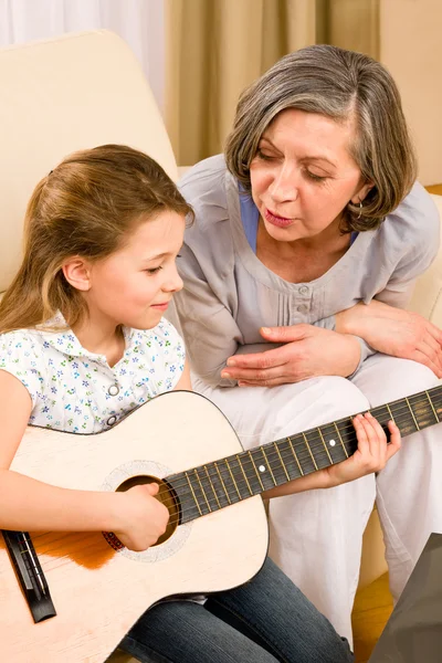 Mladá dívka zpívat hrát na kytaru na babičku — Stock fotografie