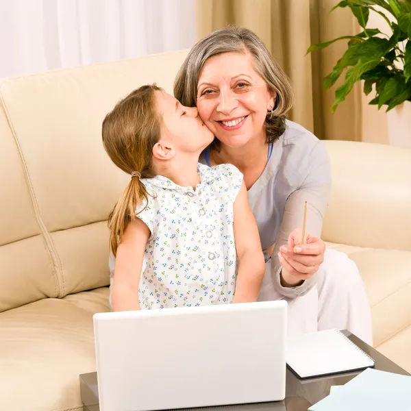 Granddaughter giving kiss to grandmother smiling — Stock Photo, Image