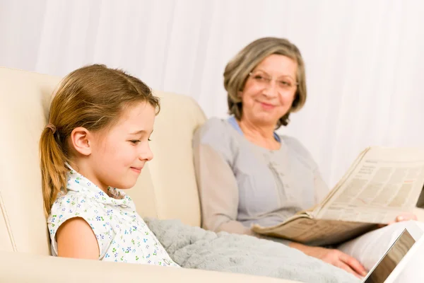 Giovane ragazza utilizzando laptop nonna rilassarsi — Foto Stock