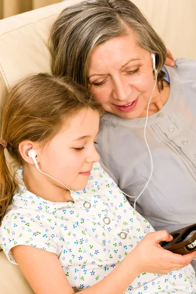 Grootmoeder en jong meisje luisteren muziek samen — Stockfoto