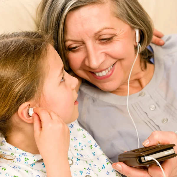 Grandmother and young girl listen music together — Stock Photo, Image