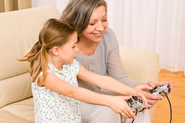 Бабушка и внучка играют в компьютерные игры — стоковое фото