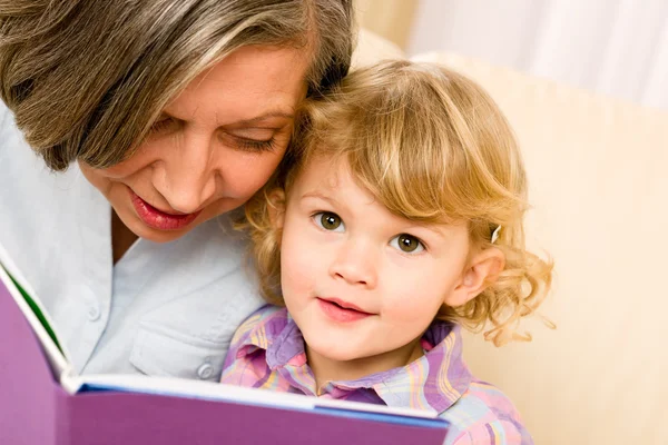 Grandmother and granddaughter read book together — Stock Photo, Image