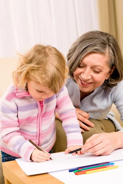 Grandmother and granddaughter drawing at home — Stock Photo, Image