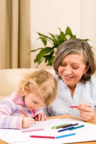 Маленькая девочка с бабушкой рисуют вместе — стоковое фото