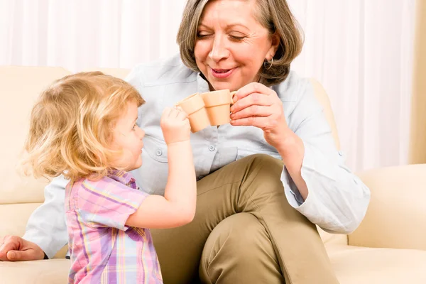 Бабушка с внучкой пьют крошечные чашки — стоковое фото