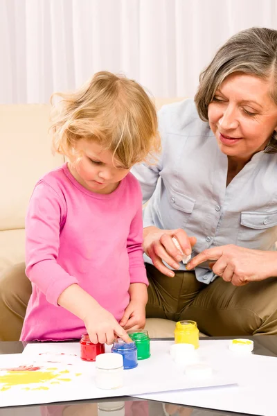 Stock image Little girl with grandmother play paint handprints