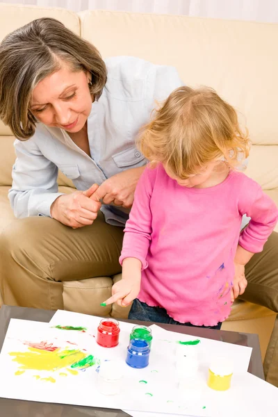 Little girl with grandmother play paint handprints — Stock Photo, Image