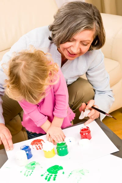 Kleines Mädchen mit Großmutter spielen Farbhandabdrücke — Stockfoto