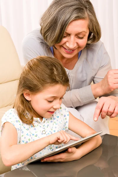 Nonna con nipotina uso tablet touch Immagini Stock Royalty Free